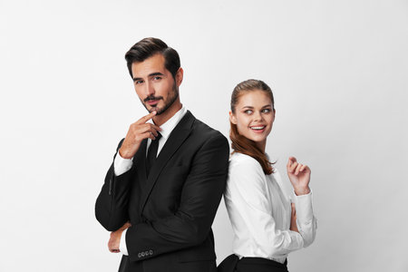 Man and woman smile with teeth business in business attire looking into camera on white isolated background. Stylish business concept paired between employees startup copy placeの写真素材