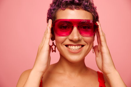 Fashion portrait of a woman with a short haircut in colored sunglasses and a smile with teeth in a...