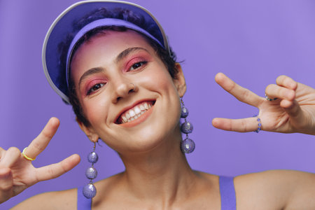 Portrait of a sporty fashion woman posing smiling with teeth at the camera with stylish earrings in...