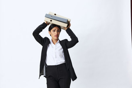 Business woman with a folder of documents in her hands in a black business suit and glasses shows signals gestures and emotions on a white background, work freelancer online trainingの写真素材