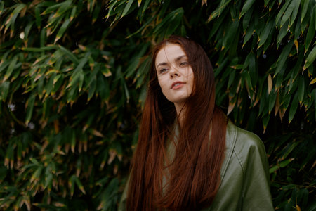 Woman Influencer in stylish trendy clothing portrait with red hair posing against a backdrop of bamboo trees, lifestyle blogger springの写真素材