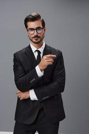Man businessman in business suit and eyeglasses with brunette beard on gray background. The concept of good business and expensive clothes a copy spaceの写真素材