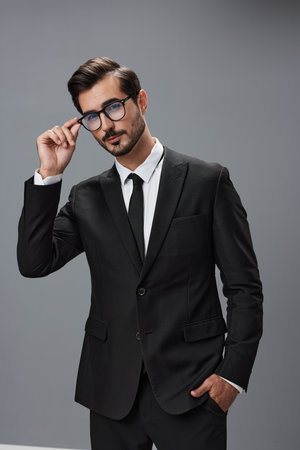 Man businessman in business suit and eyeglasses with brunette beard on gray background. The concept of good business and expensive clothes a copy spaceの写真素材