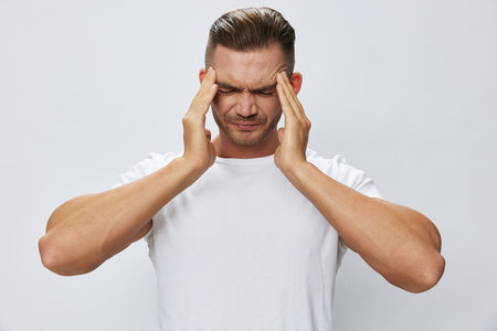 Man headache, migraine, high fever, in white T-shirt on white isolated background, copy spaceの写真素材