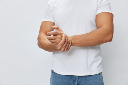 Man arm pain, sprain and muscle injury in white T-shirt on white isolated background, copy spaceの写真素材