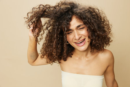 Woman combs curly afro hair with wooden comb, home beauty care styling products, hair loss aの写真素材