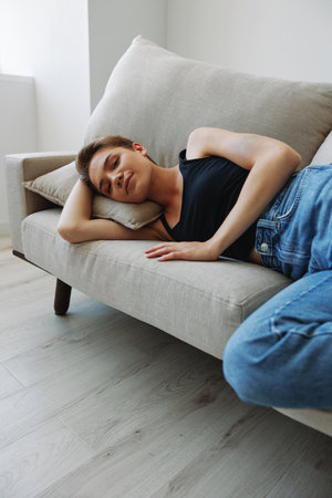 Young woman with short haircut hair having fun at home on the couch smile and happiness, vacation at home, natural posing without filters, free copy spaceの写真素材