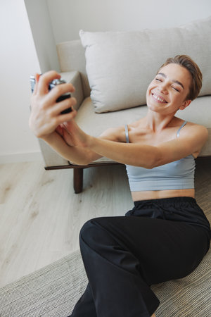 Happy smile woman holding an old camera and taking pictures of herself as a weekend photographer in home clothes with a short haircut hair without filters on a white background, free copy spaceの写真素材