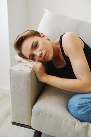 Young woman with short haircut hair having fun at home on the couch smile and happiness, vacation at...
