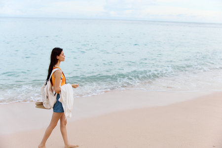 Woman smile with teeth after swimming in the ocean with a backpack in a wet yellow tank top and...