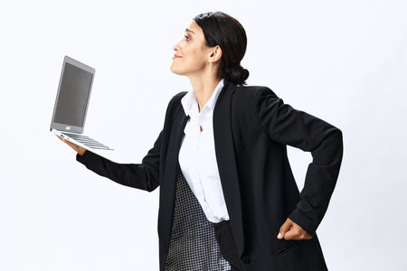 Business woman with laptop in hand in black business suit shows signals gestures and emotions on white background, freelancer job online trainingの写真素材