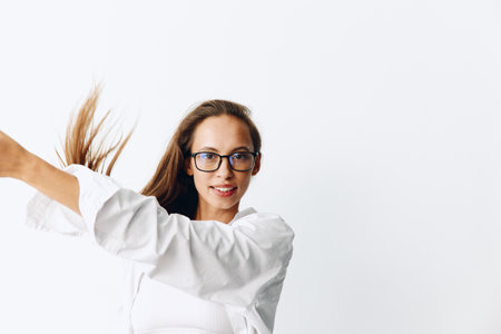 Woman portrait with tanned skin and long natural flowing hair posing on a white background wearing eyeglassesの写真素材