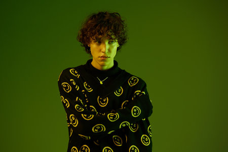Man fashion and style accessories model with curly hair stylish sweater, hipster teen lifestyle,...