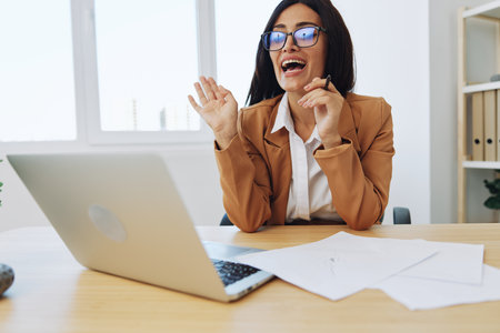 Business woman working in the office at her desk with a laptop, smile and business dialogue via video link, hand gestures in dialogue, online internetの写真素材