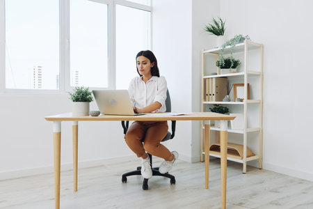 Woman business working at her laptop at home in her office, freelance employee in business, happiness of working online, technology in businessの写真素材