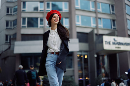 A business woman walks in the city against the backdrop of office buildings, stylish fashionable vintage clothes and make-up, spring walk, travel.の写真素材