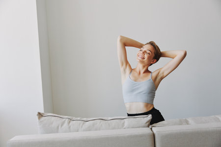 Happy woman smile lying at home on the couch relaxing on a weekend at home with a short haircut hair without filters on a white background, free copy spaceの写真素材