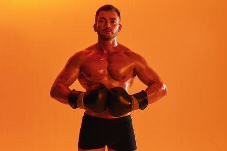 Man bodybuilder boxer muscle workout with naked torso. Advertising, sports, active lifestyle, colored yellow light, competition, challenge concept.の写真素材