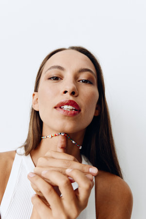 Portrait of a young beautiful woman with tanned skin model on a white background in a white T-shirt...