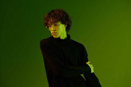 Man portrait in glasses fashion and style emotion model poses, hipster teen lifestyle, portrait green background mixed neon light, copy spaceの写真素材