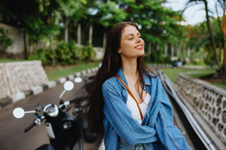Portrait of a woman brunette smile with teeth walking outside against a backdrop of palm trees in the tropics, summer vacations and outdoor recreation, the carefree lifestyle of a freelance student.の写真素材