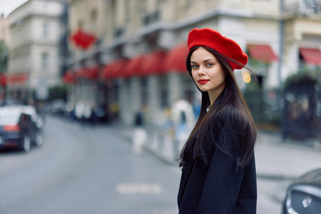 Fashion woman portrait beauty standing on the street in front of the city in stylish clothes with red lips and red beret, travel, cinematic color, retro vintage style, urban fashion lifestyle.の写真素材