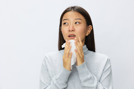 Asian woman holding hand with handkerchief and coughing up flu and cold, stuffy nose viral diseaseの写真素材