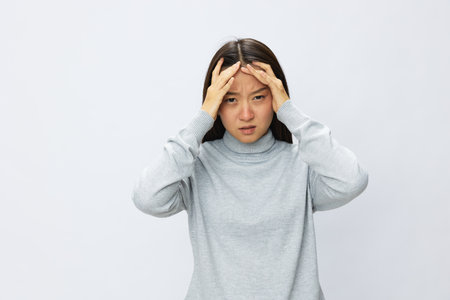 Asian woman holding her hand to her head for severe headache, migraine white backgroundの写真素材