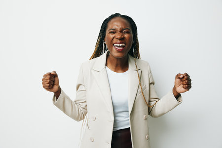 Portrait african american business woman happiness and smile dance, business clothes and jacket with afro pigtails smile. White background. Soft warm colors.の写真素材