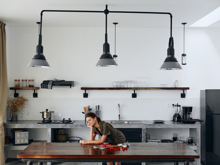 Happy woman chef smile with teeth in Stylish kitchen interior with natural elements in wood and stone design with fresh produce for dinner on the table, copy place, homemade food in a clean roomの写真素材
