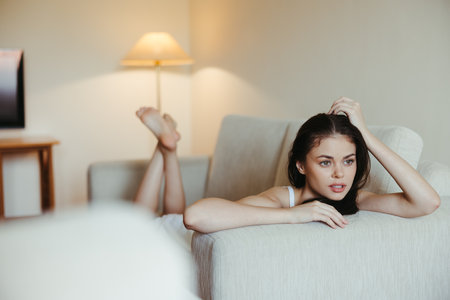 Happy girl smile lying on the couch at home, relaxing at home, comfort, sunshine.の写真素材