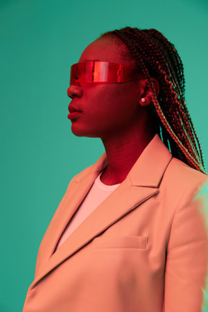 African american woman smile and fashion wearing glasses green background in neon light color mixed light, bright color dancing, futuristic party. Beauty African American woman with pigtails emotions.の写真素材