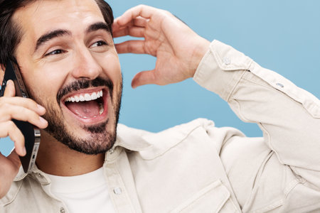 Close-up portrait of a brunette man talking on the phone, smile with teeth open mouth happiness, on...