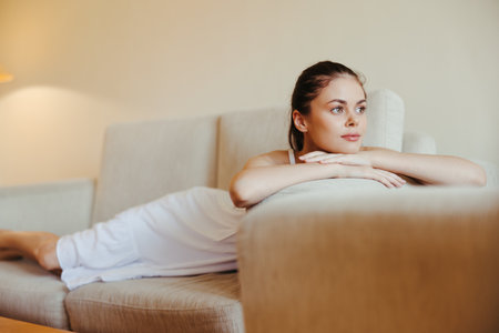 Happy girl smile lying on the couch at home, relaxing at home, comfort, sunshine.の写真素材