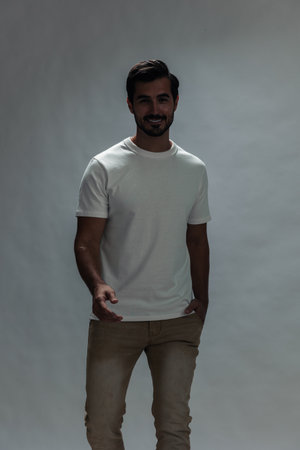 Fashion man jumping and running in a white t-shirt and jeans, smile with teeth joy on a white...