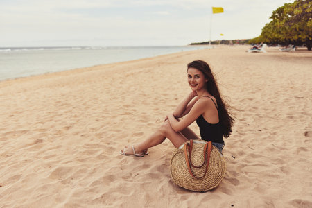 beach woman nature sand vacation sea sitting travel freedom attractive smileの写真素材