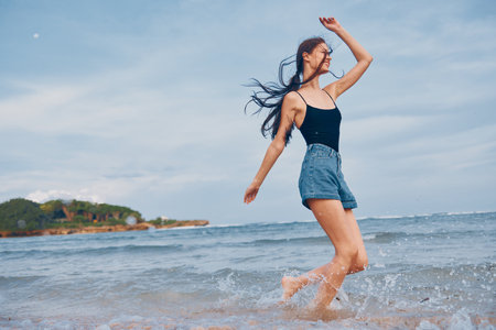 woman young running summer sunset smile sea positive beach lifestyle travelの写真素材