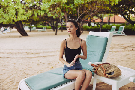 woman sand resort sunbed sea lying ocean chair beach lifestyle smilingの写真素材