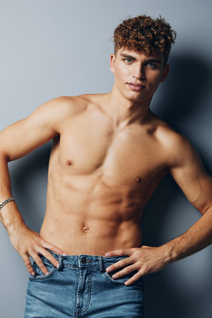 man care athletic sexy model gray background handsome person beauty adult male jeansの写真素材