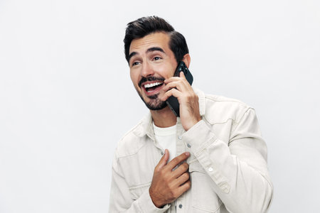 Closeup portrait man talking on the phone smile with teeth happiness and laughter on white isolated background, fashion style clothes, copy space, space for textの写真素材