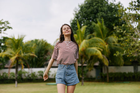 woman park lifestyle freedom beautiful hat walk t-shirt smiling nature summerの写真素材