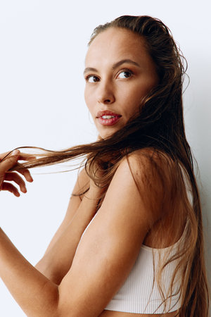 A woman with long, wet hair sits with her head tilted back after washing. Taking care of your hair...