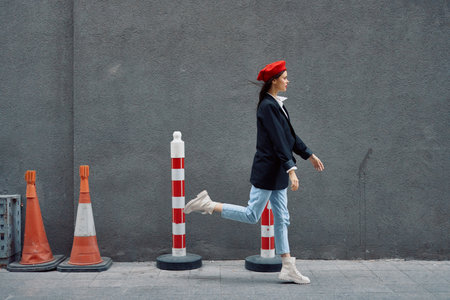 Fashion woman running down the street in front of the city tourist in stylish clothes with red lips and red beret, travel, cinematic color, retro vintage style, late to work, run.の写真素材