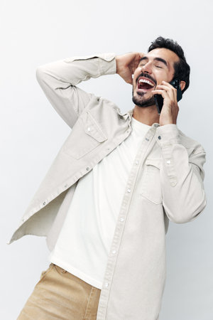 Closeup portrait man talking on the phone smiling and laughing happiness communication on white isolated background, fashionable clothing style, copy space, space for textの写真素材