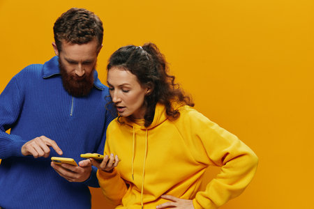 Woman man cheerful couple with phones in hand social networking and communication crooked smile fun...