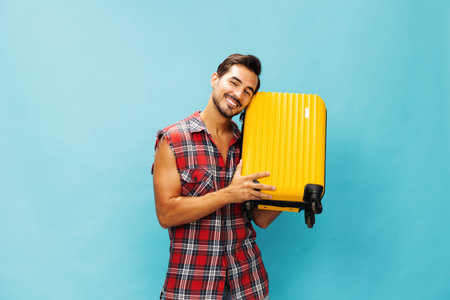 Vacation man guy yellow background traveler journey flight travel studio trip baggage happy suitcase weekendの写真素材