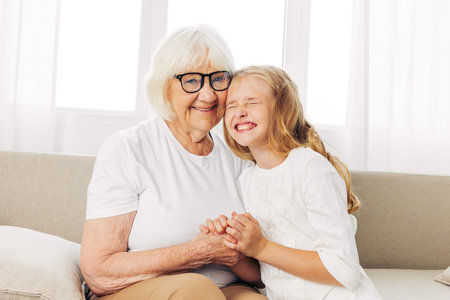 Woman old love home granddaughter child happy couch family grandmother sofa girlの写真素材