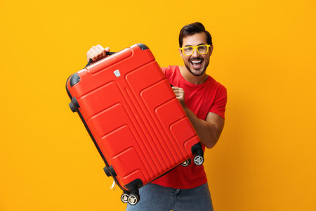 Baggage man happy trip flight traveler guy suitcase background vacation yellow weekend studio journey travelの写真素材