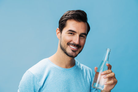Sport man smile happy studio lifestyle t-shirt bottle attractive healthy drink waterの写真素材