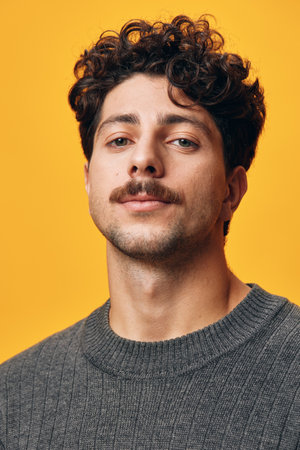Young man hair student happy smile portrait sweater orange trendy background hispanic fashion